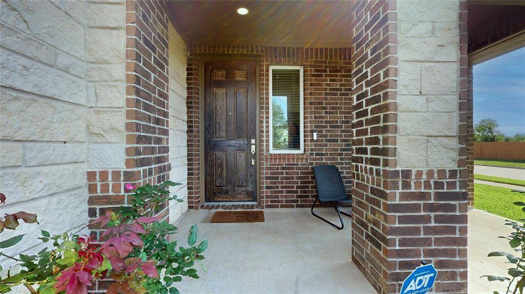 Welcome home to 22523 Strathmore Drive. This charming home features a covered front porch entrance with a mix of brick and stone exterior and a sturdy wooden door.