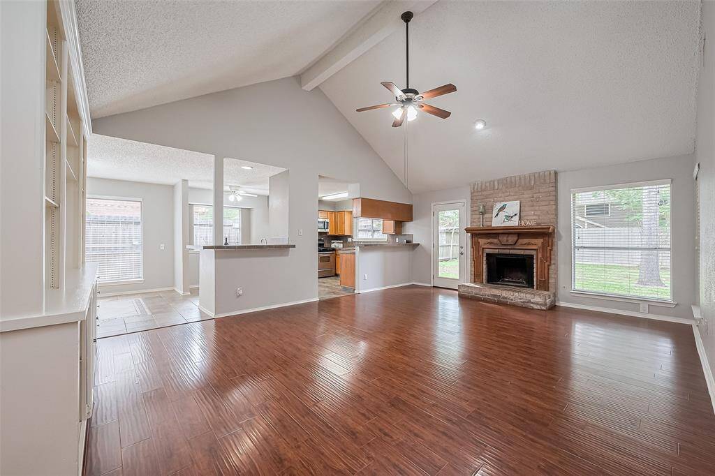 Welcome home! Warm & inviting bright, open plan with high vaulted ceilings, a cozy brick fireplace, and rich flooring. Perfect for comfortable living and entertaining.