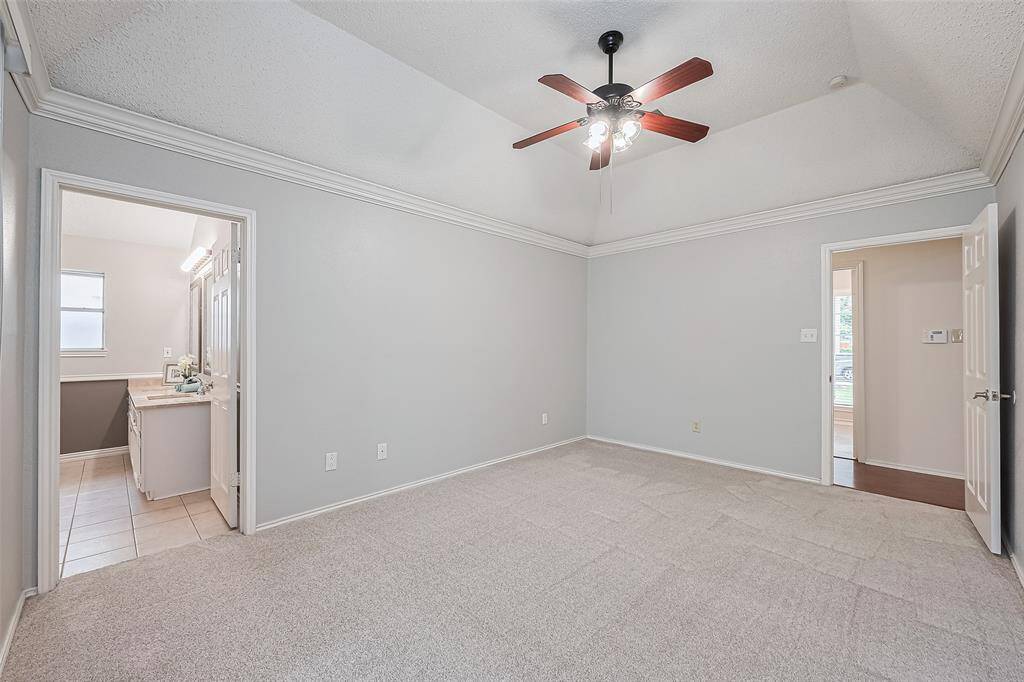 Another view of the tall ceilings, crown molding and a view to the ensuite bath.