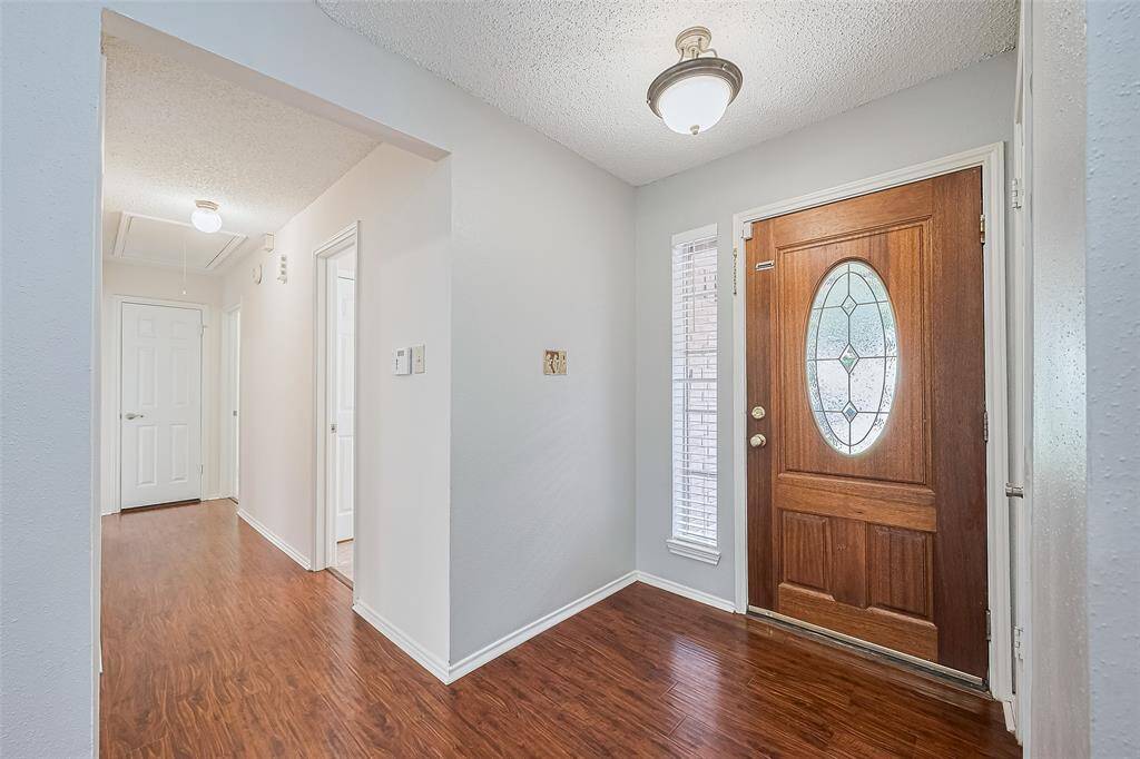 Step into the inviting entry which includes a coat closet to the right. A view down the hall to the bedrooms, bathroom and a storage closet.