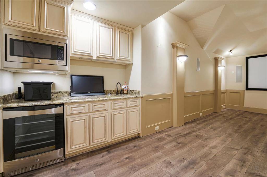 Spacious theater room with a stylish wet bar and built-in microwave. Perfect for entertaining!