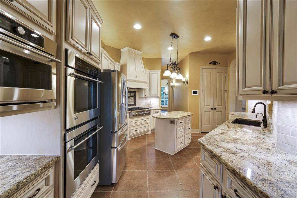 This kitchen is equipped with a double oven, microwave, and trash compactor, offering convenience and efficiency.