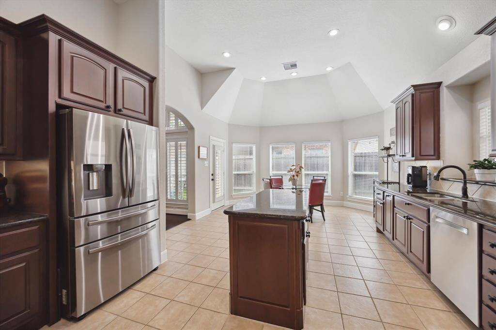 At the window end of the kitchen is a rather expansive breakfast table area overlooking the back yard.  The door to the left of the dining table leads to a covered patio.