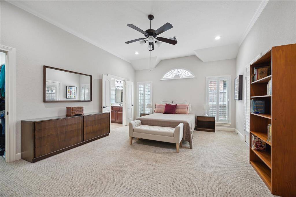 Look at this expansive primary suite!  The bath is just visible to the far left in the back, and just out of view beyond the bookcase is a door to the back yard patio.