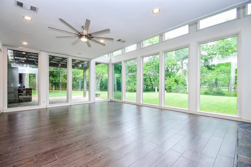 Sunken living area with massive 2 story windows and porcelain wood grain flooring. Door from the living area leads out to a beautiful patio area