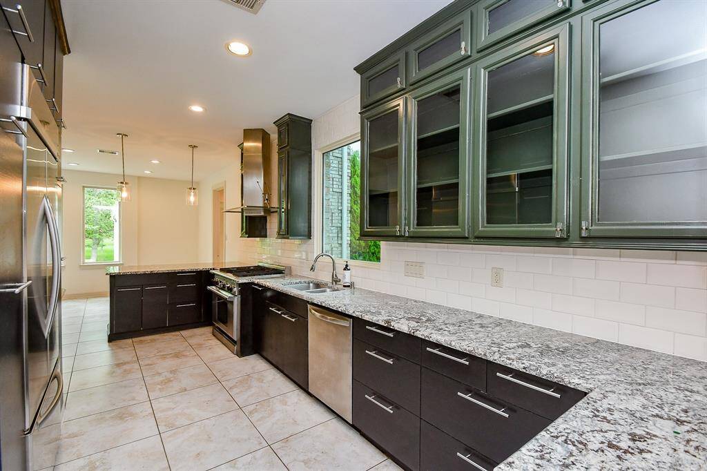 Kitchen features espresso cabinets, stylish hardware pulls, built in fridge, granite and large breakfast area