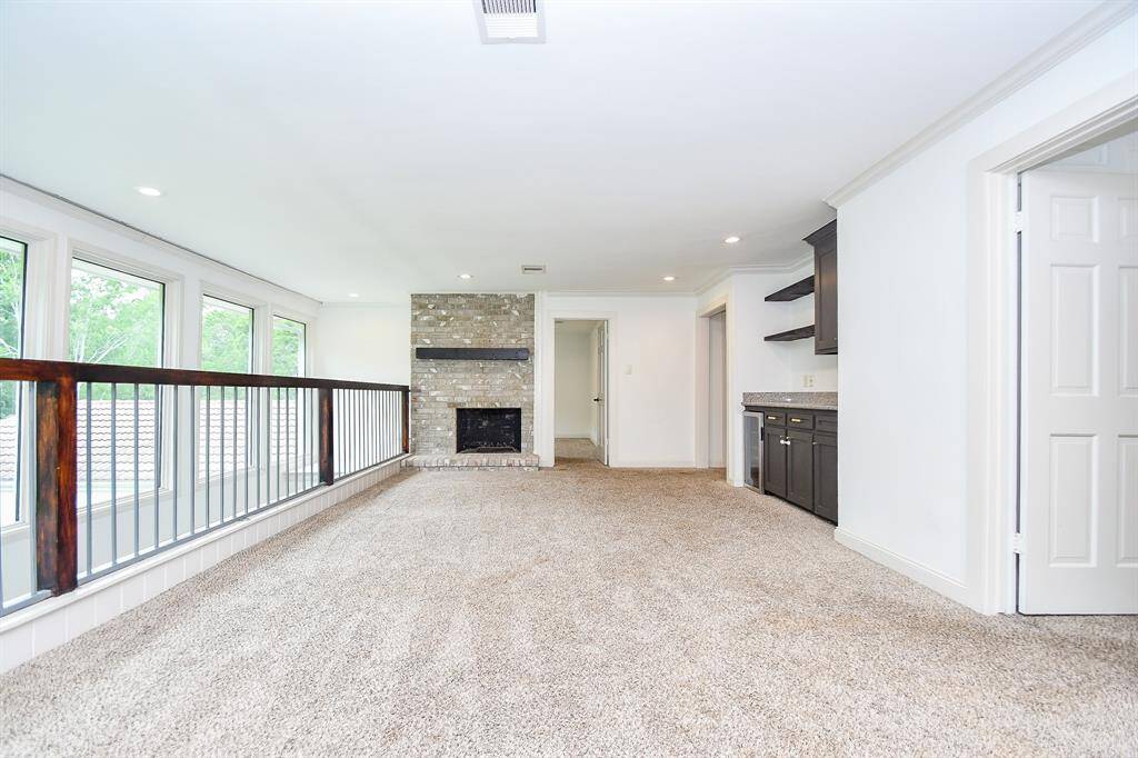 Upstairs showcases a spacious lofted game room or second living area