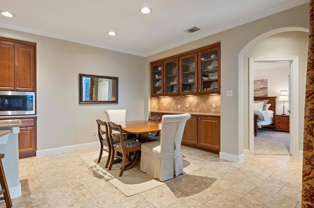 An expansive dry bar or secondary butler’s pantry enhances functionality and style. Featuring sleek granite countertops and an abundance of cabinetry, it provides the ideal space for serving, storage, or setting up a coffee or beverage station.