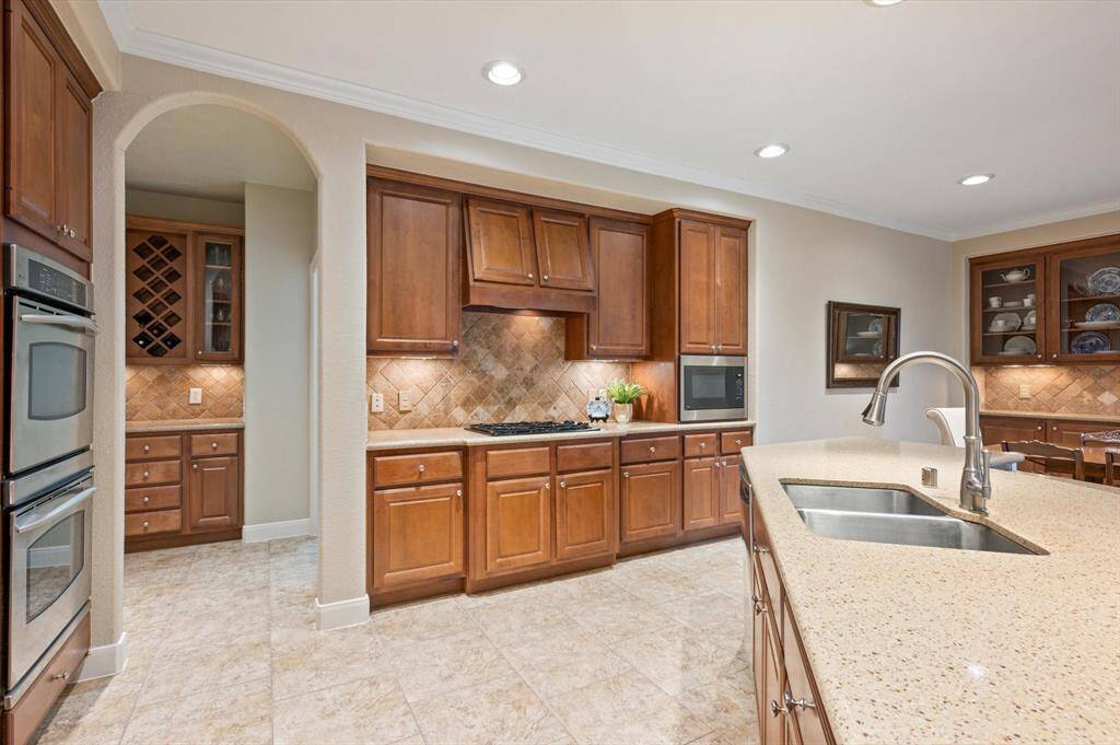 Crown molding adds a refined touch, while recessed lighting and undercabinet lighting highlight the elegant finishes and creates a welcoming ambiance.