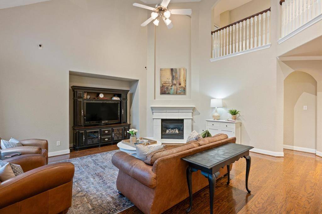 A gas-log fireplace with an elegant cast stone surround serves as a striking focal point, offering both visual appeal and cozy comfort on cooler evenings. An entertainment nook provides a stylish and functional space to showcase your media setup or favorite decor pieces.