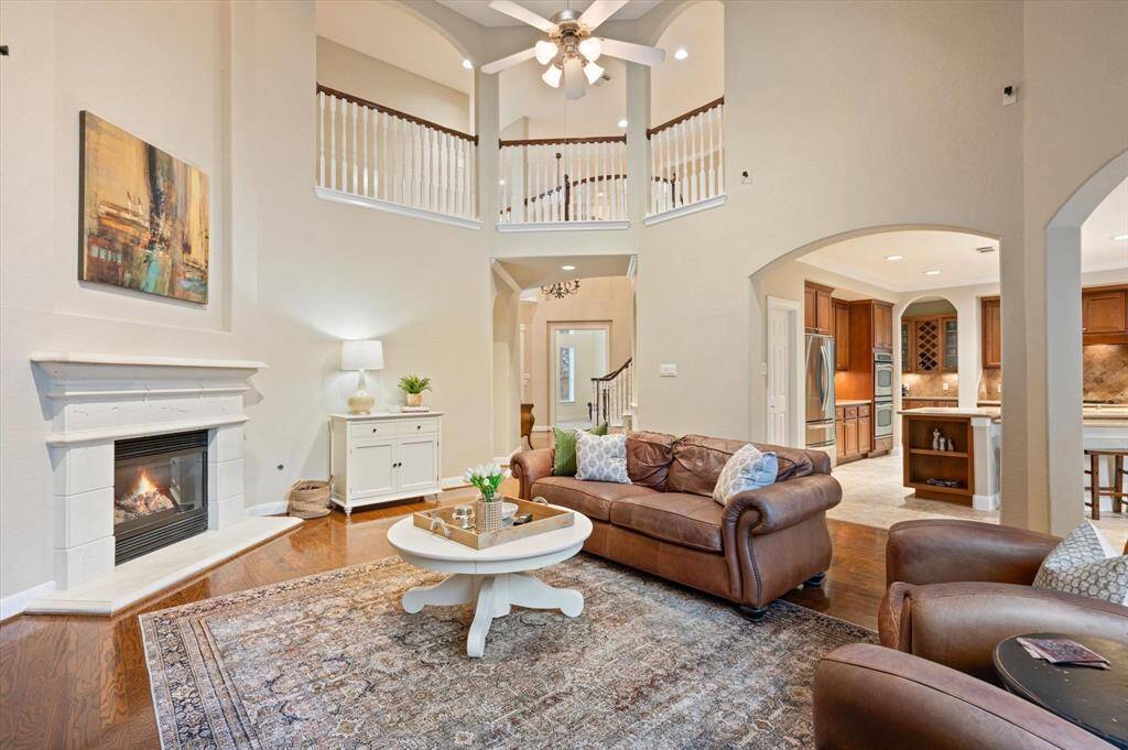 Whether you’re hosting guests, enjoying a quiet night in, or gathering with family, this beautifully designed space offers the perfect blend of sophistication and comfort. Soaring ceilings create an airy, open atmosphere, while rich wood floors add warmth and character.