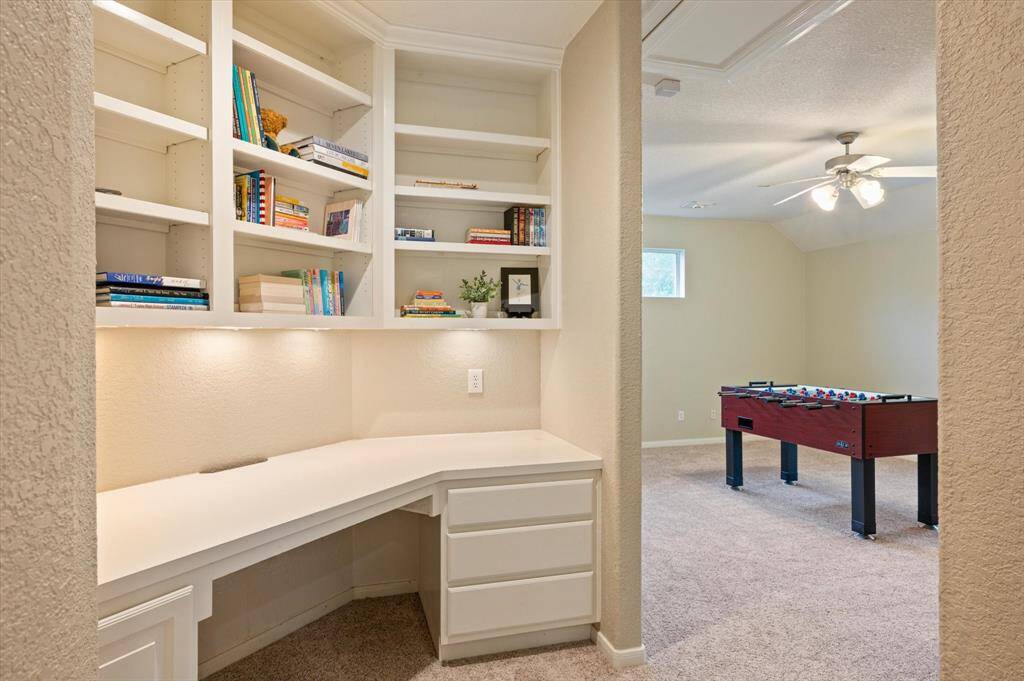 A built-in desk area provides a functional and versatile space perfect for work, study, or creative pursuits. Overhead shelving offers ample room for books, décor, or supplies, while undercabinet lighting creates a well-lit and inviting workspace.
