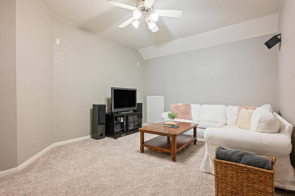 Located behind double doors, this versatile media room is the perfect setting for immersive entertainment. Featuring a high ceiling with a ceiling fan, plush carpeting for added comfort, and pre-wiring for surround sound speaker.