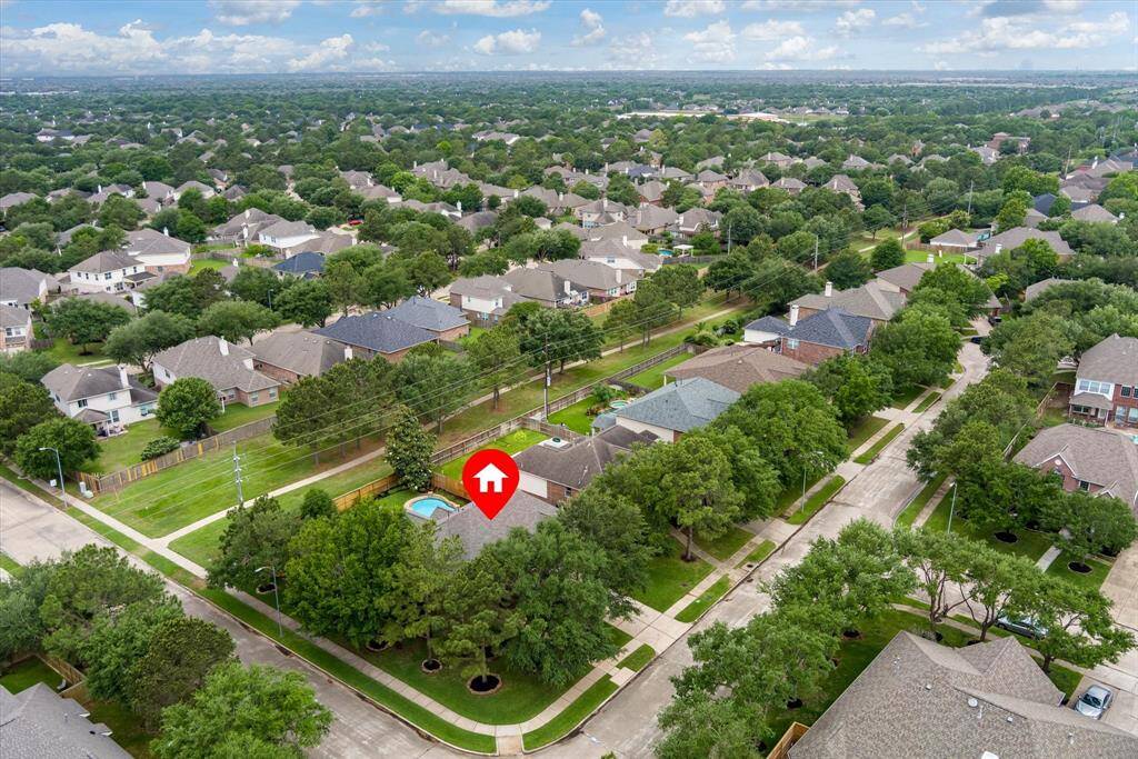 An aerial view showcases the expansive corner lot, beautifully positioned with no rear neighbors as it backs up to a serene greenbelt. This unique setting offers added privacy, scenic views, and a sense of openness.