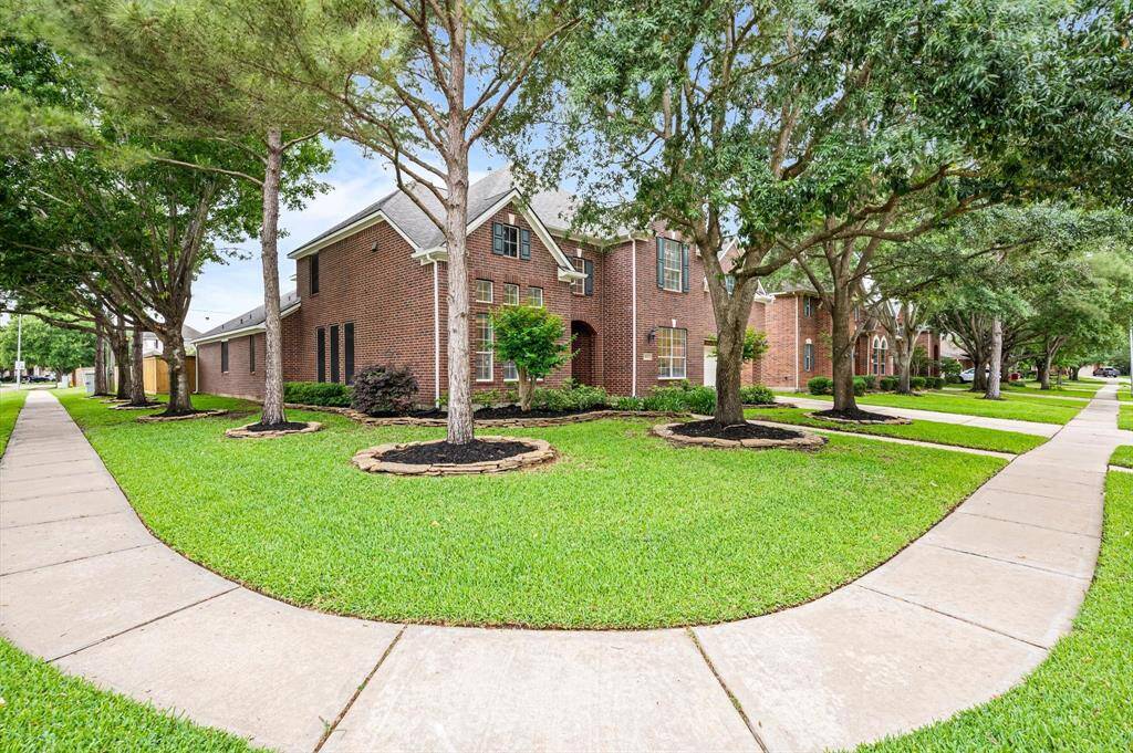 This expansive, tree-lined corner lot boasts exceptional curb appeal, with mature landscaping and a commanding presence that sets the tone for the entire property.