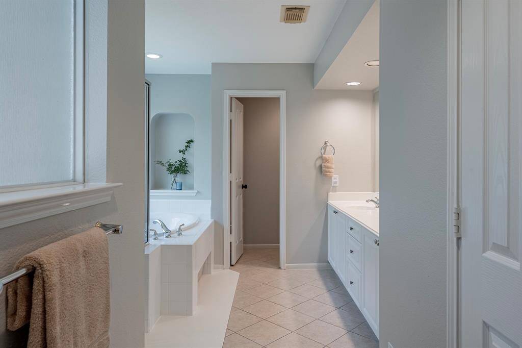 Primary ensuite. Separate shower, soaking tub with elegant alcove and dual vanities. Generous walk-in closet to your right.