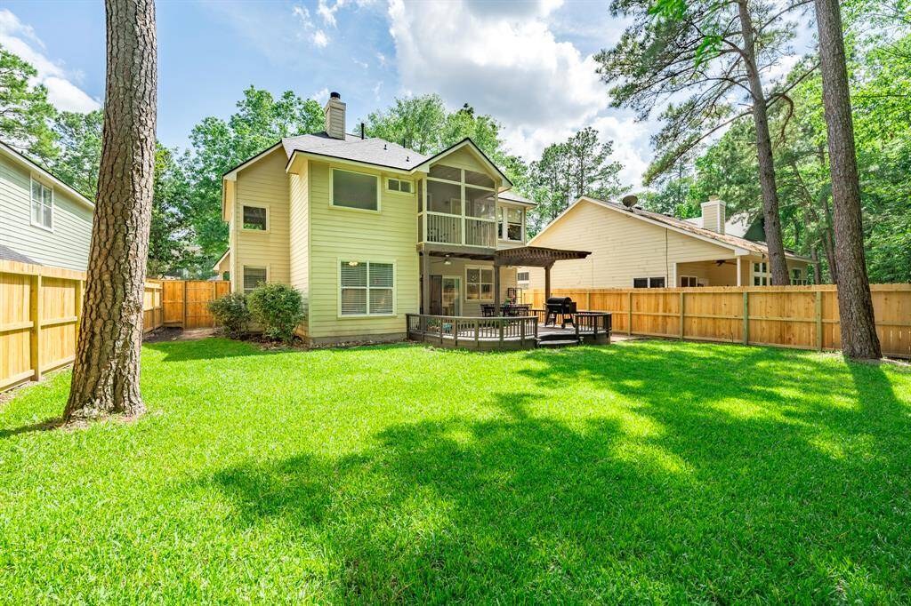 Large trees stand guard and frame this back view of the home.
