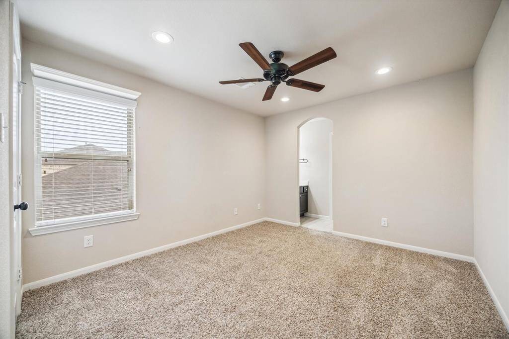 Guests will feel right at home in this spacious suite. This spacious bedroom offers plush carpet, neutral paint, a lit ceiling fan, a large closet and ensuite access to a full bathroom.
