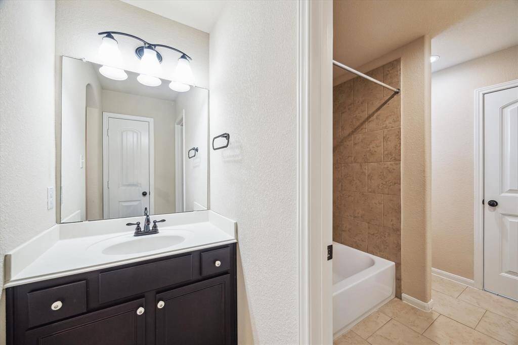 Morning routines are a breeze with two full bathrooms upstairs, including this convenient Hollywood-style bath with twin vanities and a shared water closet.