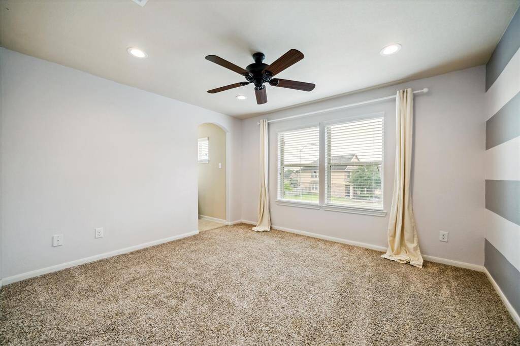 Family or guests will rest comfortably in this spacious upstairs guest suite, featuring plush carpet, neutral paint, a lighted ceiling fan, and a large closet. Enjoy the convenience of ensuite access to a full Hollywood-style bathroom.