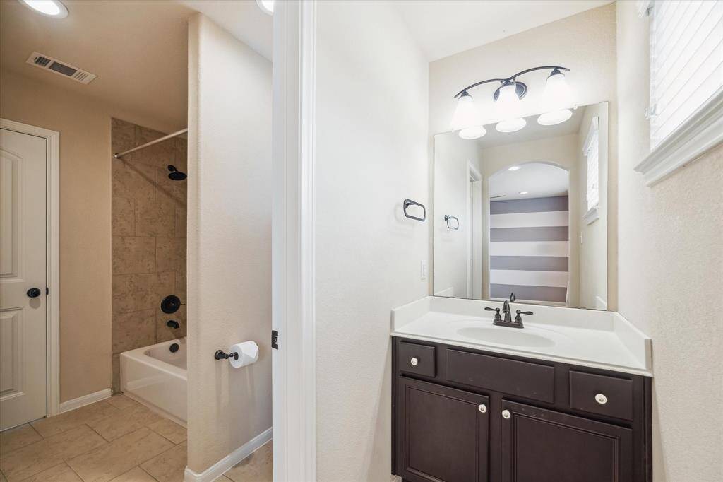 The two upstairs suites are thoughtfully designed with private ensuite dressing areas, each featuring a single sink vanity and ample storage. A shared water closet and tub/shower combination provide both privacy and convenience for family or guests.