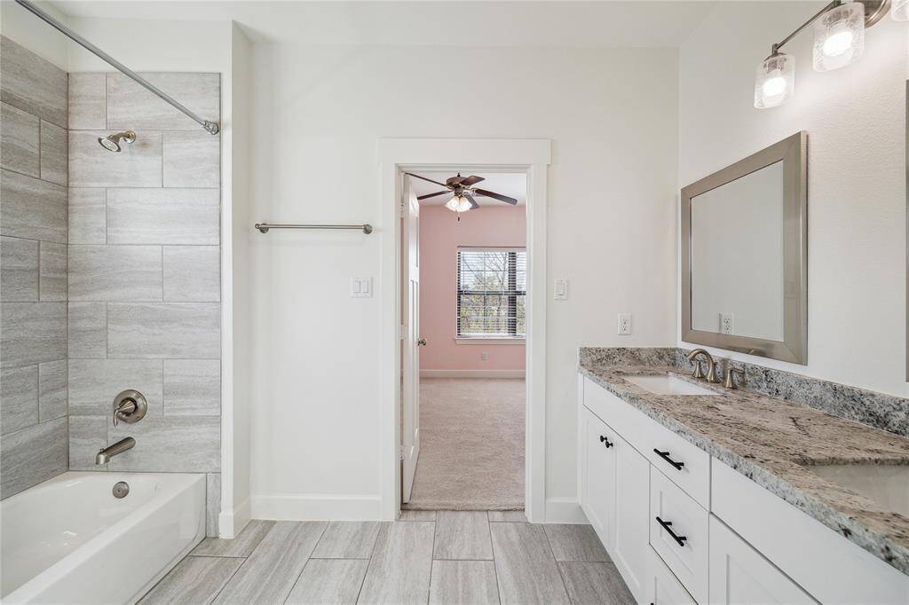 Shared bath serves the two guest bedrooms. Note the beautiful granite countertops, double sinks, and tub/shower combo.