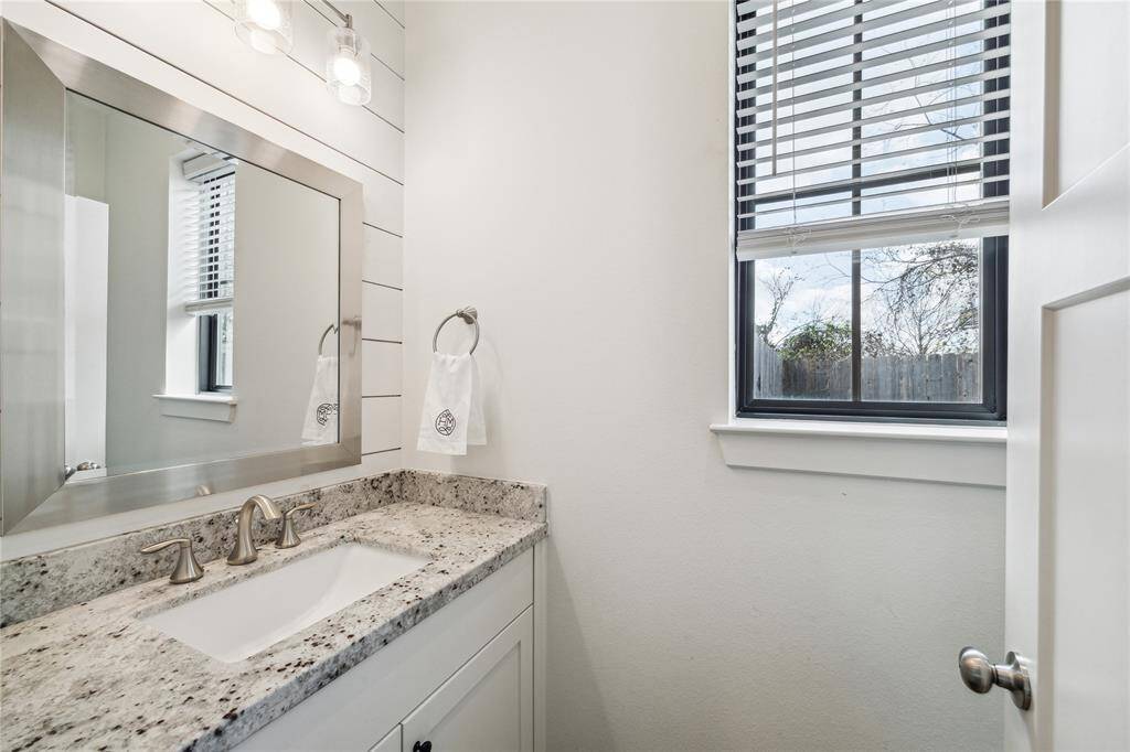 Powder bath featuring shiplap accent wall and tasteful light fixture.