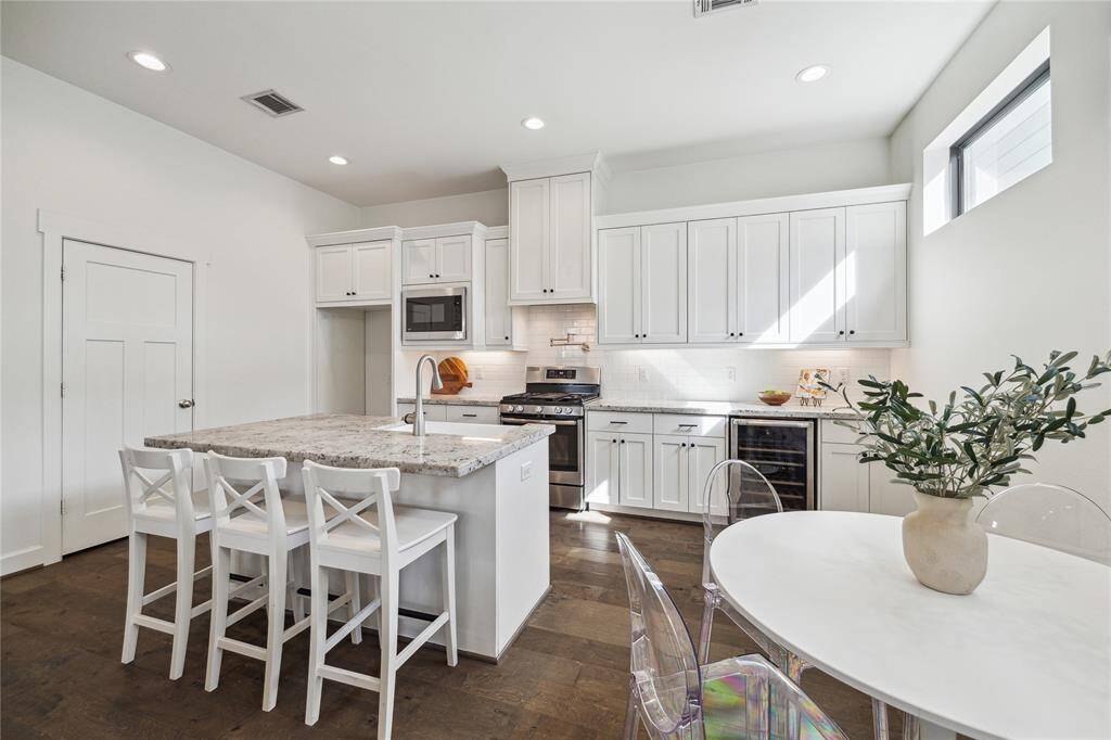 Island kitchen with breakfast bar, wine fridge, tons of storage, and pot filler.