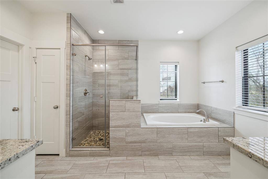 Another view of the primary bath with private water closet, linen closet, separate tub and shower (with bench).