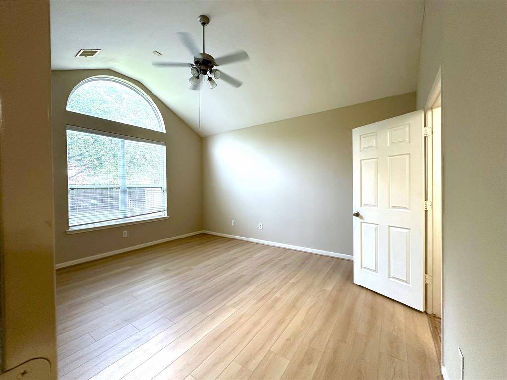 Master bedroom with plenty of natural light, vaulted ceiling and new floors.