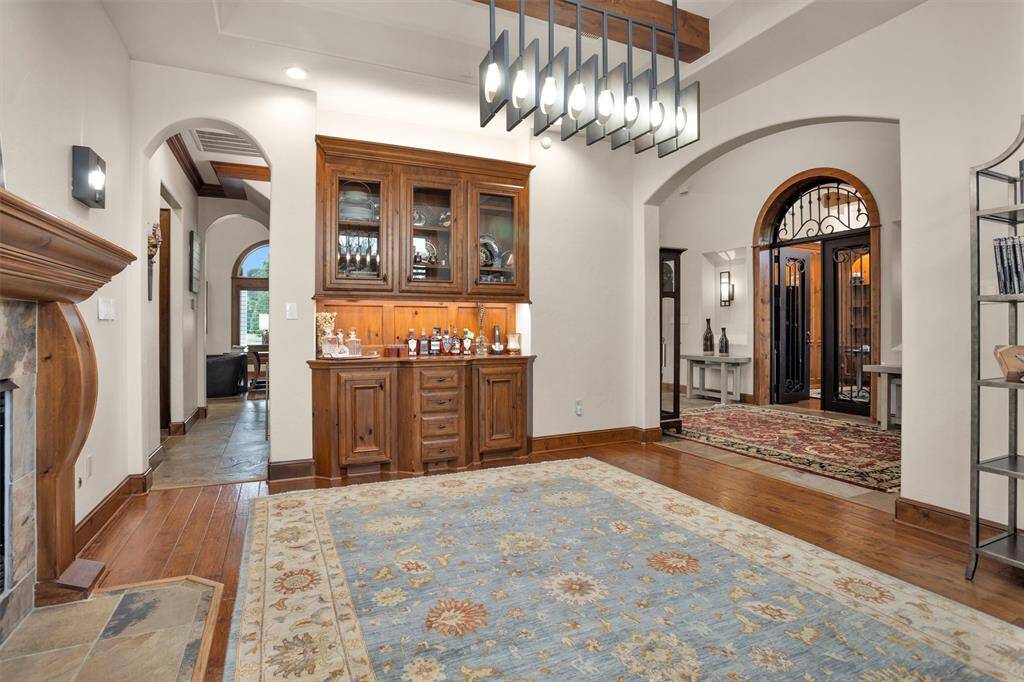 A custom built-in bar and natural wood cabinetry bring elevated hospitality to everyday living and entertaining.