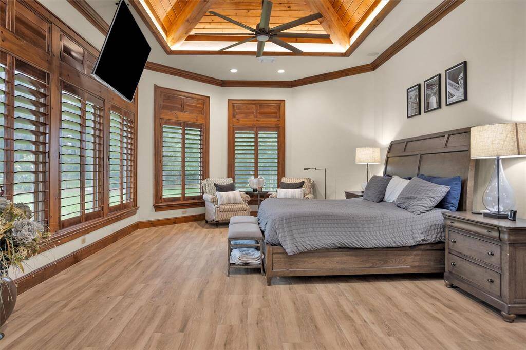 Retreat to the primary suite with vaulted ceilings, rich wood trim, and a peaceful view of the lush backyard landscape.