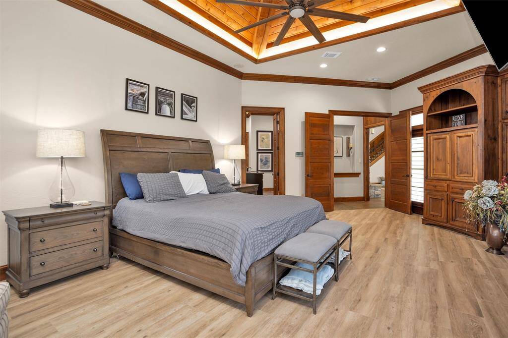 The primary bedroom offers a spacious escape with wood floors, natural light, and custom built-ins for refined comfort.