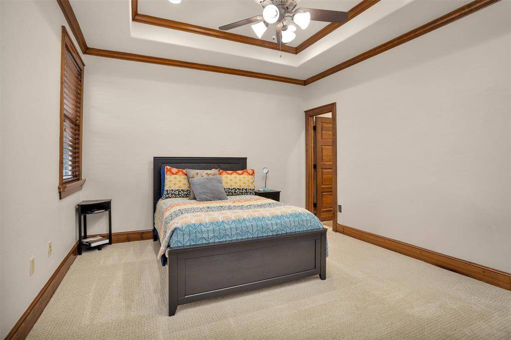 This upstairs guest suite features a tray ceiling, soft lighting, and plenty of space to unwind.