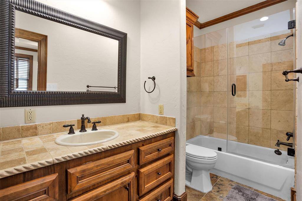 Every detail in this full bath—from the custom vanity to the neutral tile—blends warmth with timeless elegance.