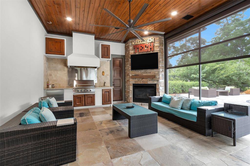 Step into the ultimate outdoor retreat. This screened-in patio features a full summer kitchen, fireplace, built-in grill, beverage fridge, and cozy seating—perfect for year-round entertaining.