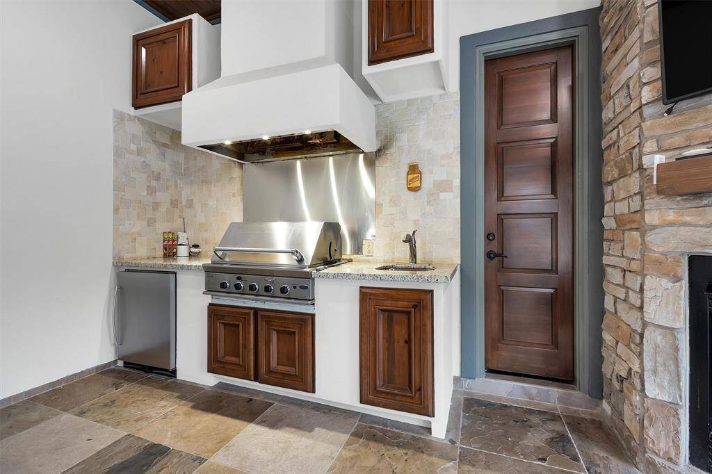 Your summer kitchen dreams come true. With a built-in grill, granite counters, prep sink, and stainless backsplash, this space is designed for both casual evenings and grand gatherings.