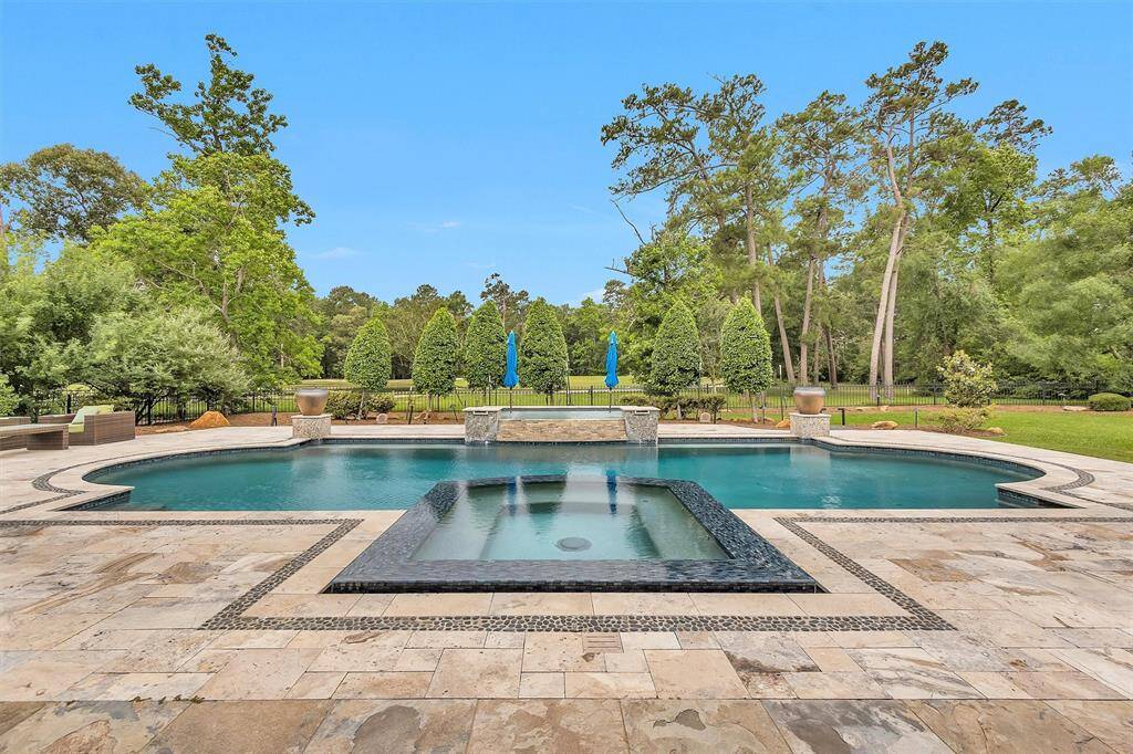 Luxury meets resort-style living in your own backyard. The custom pool with spa, sun shelf, and fire bowls overlooks the 6th green of the Augusta Pines Golf Course.