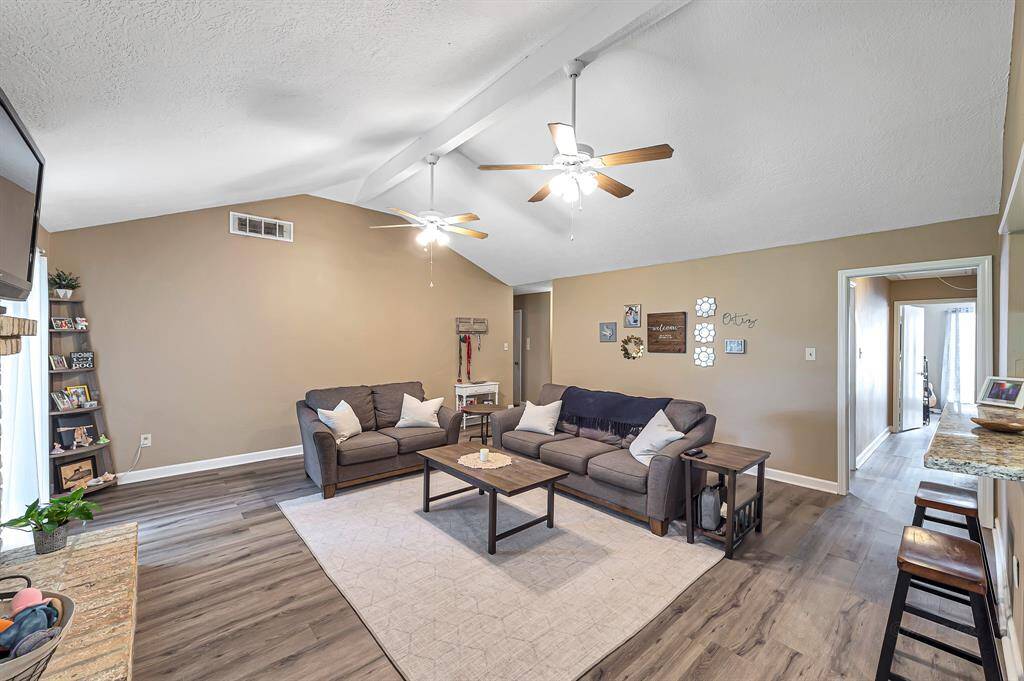 Open and airy living room. Bar seating area facing the kitchen. Gorgeous flooring flows throughout the home.