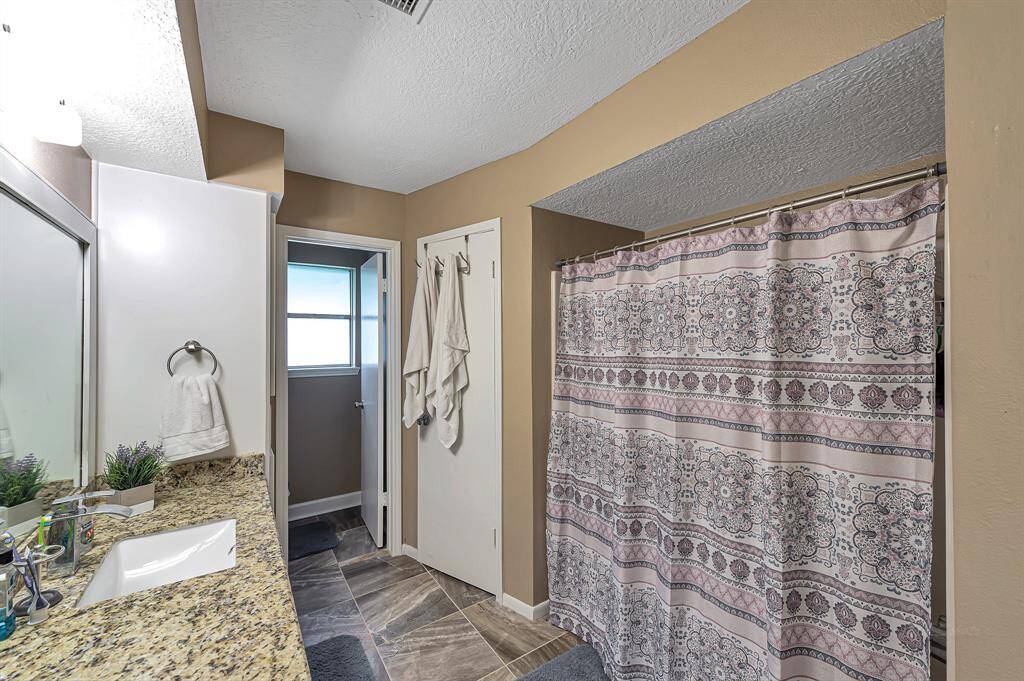 En-suite master bathroom with his and hers closets. Separate toilet area. Framed mirror and granite counters.