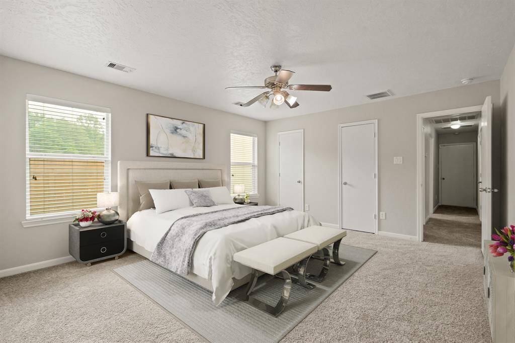 Virtually Staged: Spacious master bedroom with two built-in closets, carpet floors, a ceiling fan, and windows with privacy blinds.