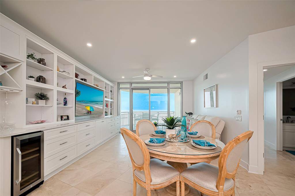 VIEWS FROM THE KITCHEN LOOKING INTO THE DEN, WINE REFRIGERATOR AND GORGEOUS CUSTOM BUILT WALL UNIT, UPGRADED CABINETRY, FLOORING AND LIGHTING!!