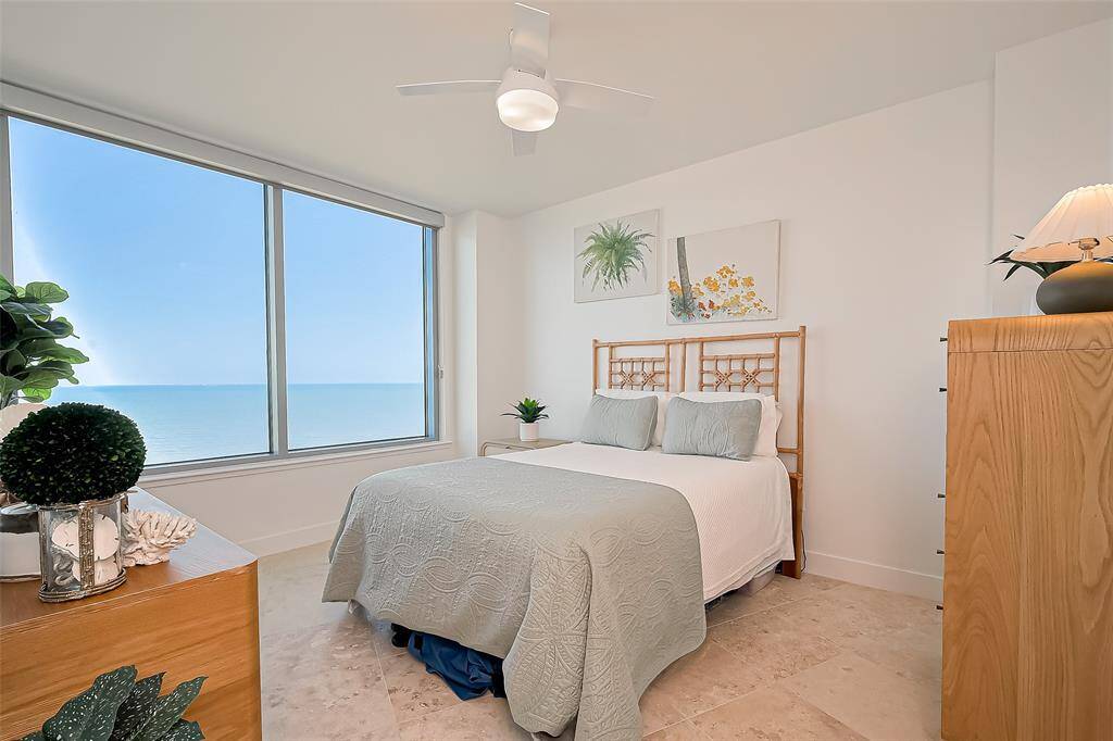MASTER BEDROOM WITH UNBELIEVABLE OCEAN VIEWS, CUSTOM LIGHTING AND SHADES AND TRAVERTINE FLOORING.