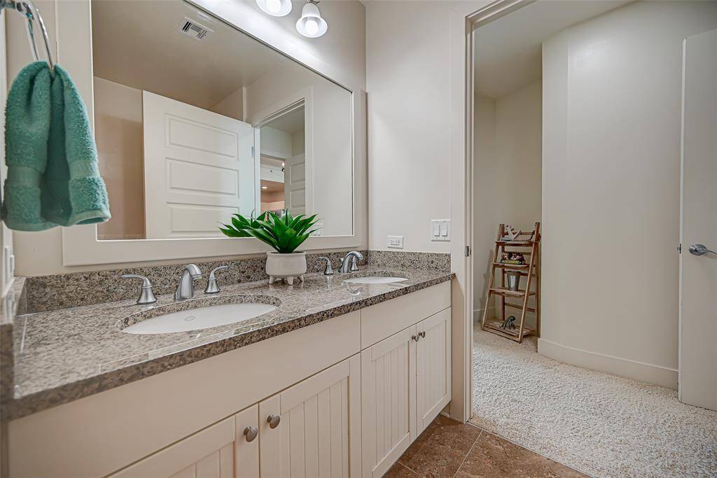 Experience spa-like luxury in this ensuite master bath featuring elegant granite countertops, his-and-hers sinks, ample storage, and a separate shower and soaking tub for ultimate relaxation.