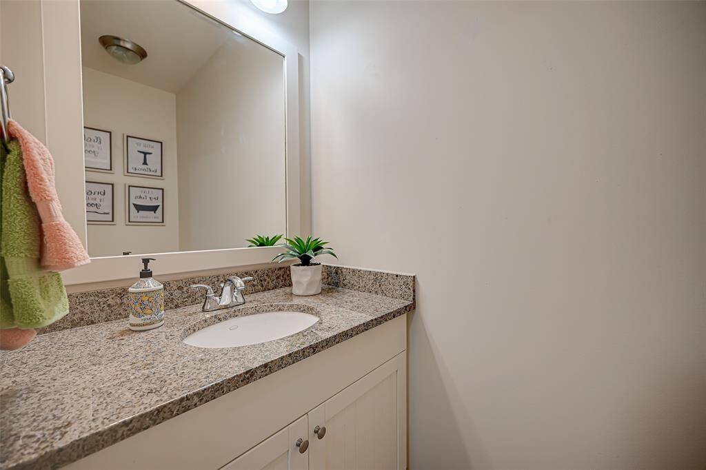 Elegant second bathroom featuring granite countertops, travertine flooring, and a separate shower.