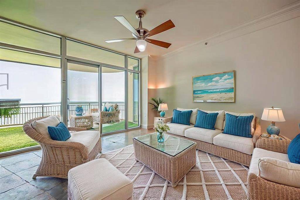 Large den area with 10 ft ceilings, natural light, and gorgeous views inside and out.  All furniture conveys if buyer wants.