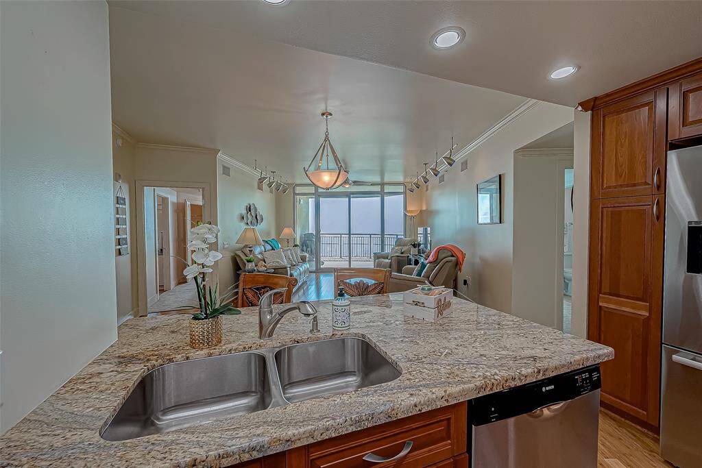 Large kitchen area with separate pantry and beautiful views of the ocean. Kitchen has upgraded cabinets, stainless steel appliances and granite countertops and backsplash.