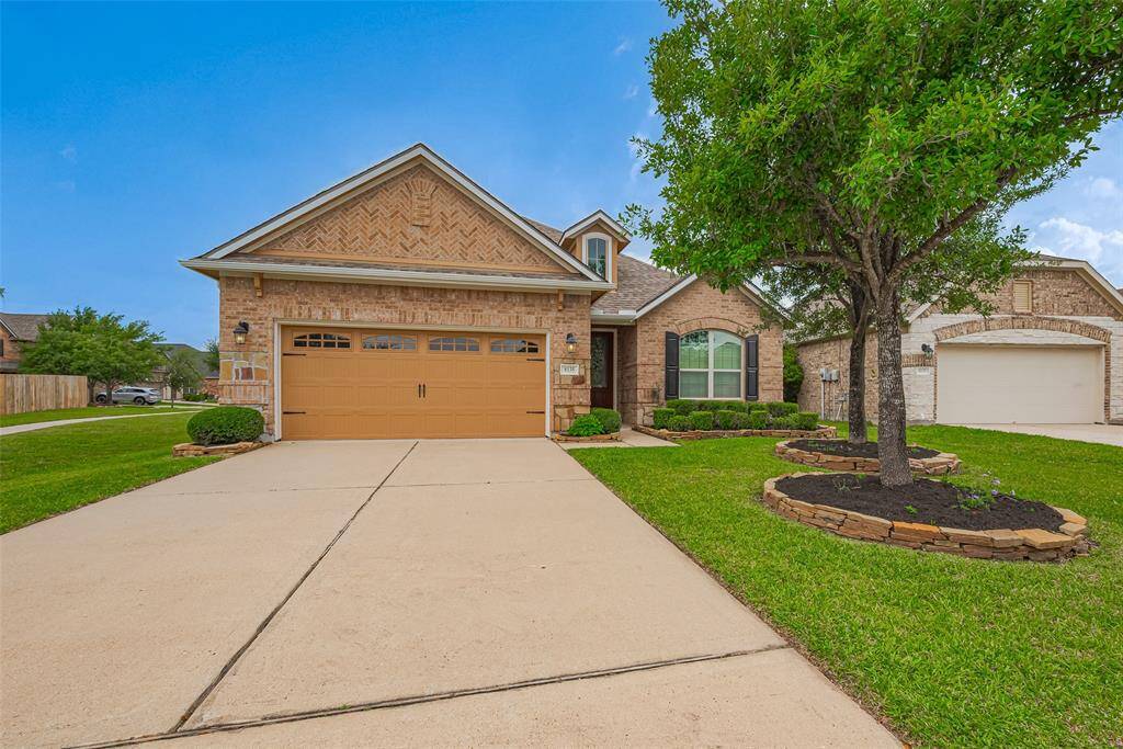 Charming brick exterior with lush lawn and smooth driveway.