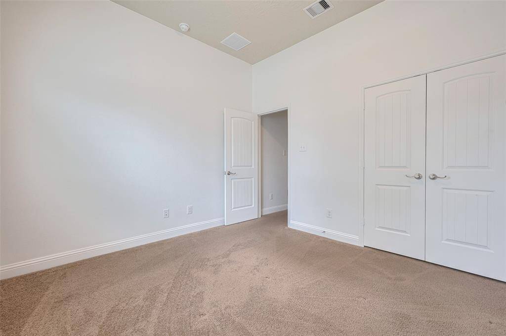 Second bedroom with plush carpeting.