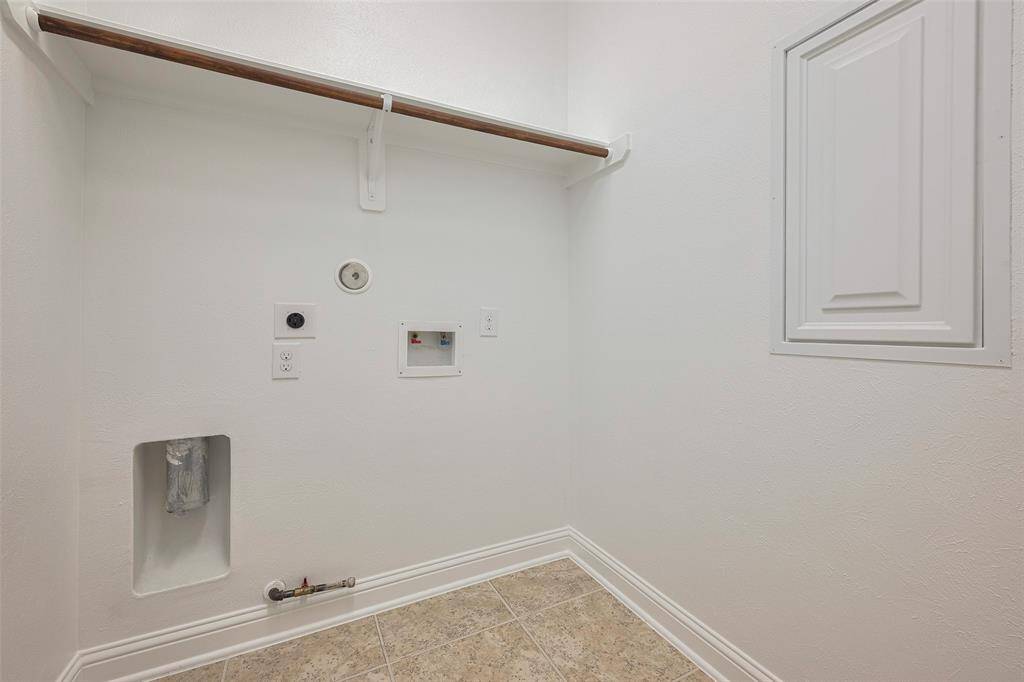 Laundry room with storage rack and hanging rod.